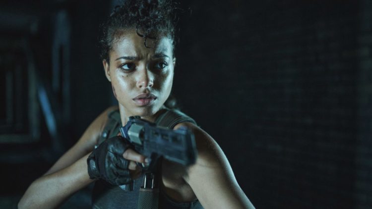 ELLA BALINKSA as JADE holding a gun in Resident Evil