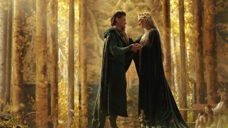 Robert Aramayo as Elrond and Morfydd Clark as Galadriel in a golden forest in The Lord of the Rings: The Rings of Power