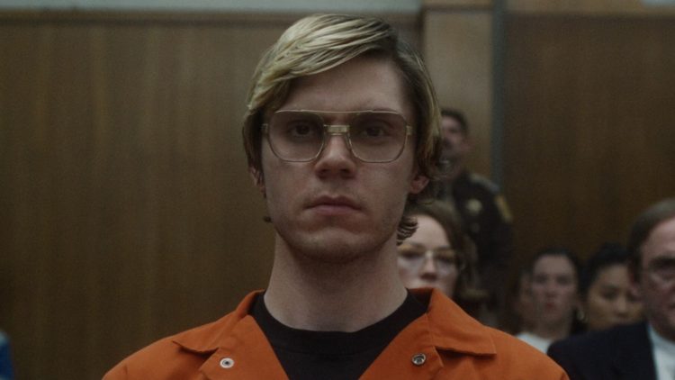 Evan Peters as Jeffrey Dahmer in orange overalls in court in DAHMER Episode 5