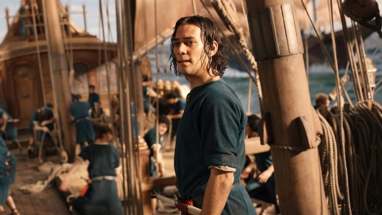 Maxim Baldry as Isildur standing on a boat in The Lord of the Rings: The Rings of Power