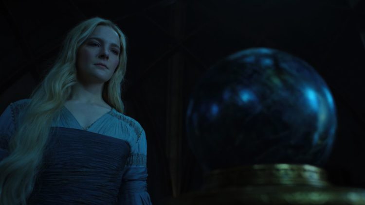 Morfydd Clark as Galadriel standing over a palantir in The Rings of Power