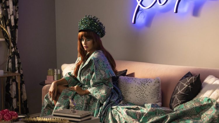 Jameela Jamil as Titania sitting in a luxurious dress in She-Hulk: Attorney at Law Episode 6