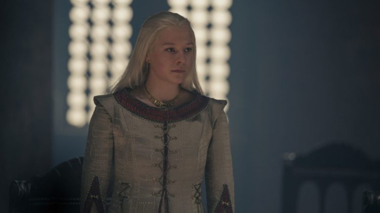 Emma D'Arcy as Rhaenyra standing in a gown in front of a window House of the Dragon Episode 6