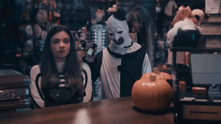 Sienna and Art the Clown standing with a horn in Terrifier 2