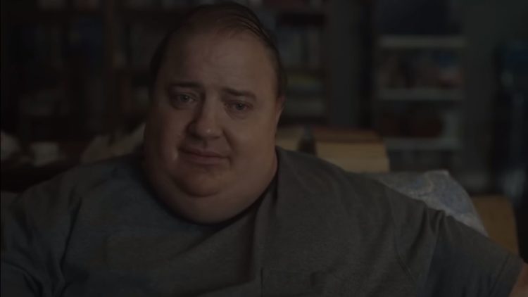 Brendan Fraser sitting on a sofa in The Whale.