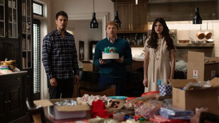 Toby Kebbell, Rupert Grint and Nell Tiger Free holding a birthday cake in Servant