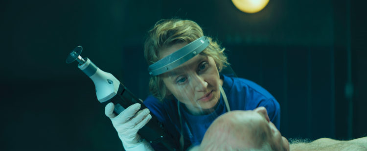 Blum examines a cadaver before starting her autopsy with a saw