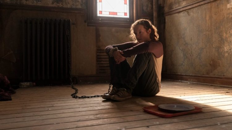 Bella Ramsey as Ellie sitting on the floor in HBO's The Last of Us